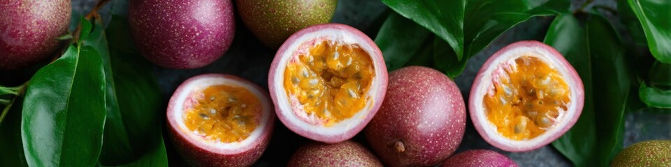 Obraz premium Fresh ripe passion fruits with green leaves displayed in close-up view