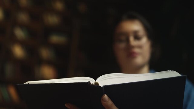 Young Asian woman studying medical literature in university library