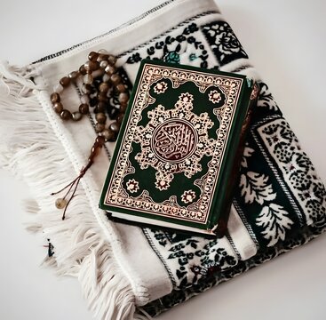 A quran and prayer accessories on a decorative mat
