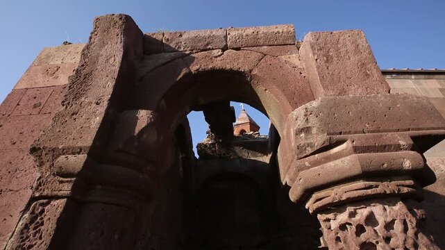 A string of decorative, colorful, triangular pennant flags with various unique illustrations gently flutters in the breeze against a blurred background of a city building and street lamps.

