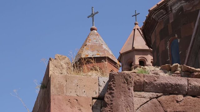 A string of decorative, colorful, triangular pennant flags with various unique illustrations gently flutters in the breeze against a blurred background of a city building and street lamps.

