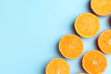 Fototapeta premium Fresh juicy tangerines on light blue background, flat lay. Space for text