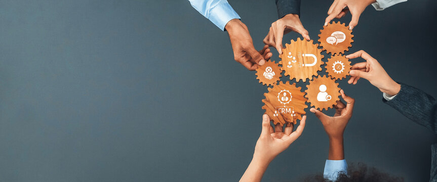 This image showcases a diverse group of hands holding interlocking gears symbolizing collaboration and innovative strategies in a business environment. Amity