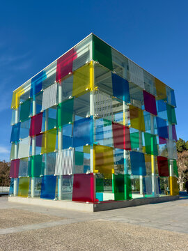 Malaga, Spain - January 19, 2026: Colourful glass cube of Centre Pompidou M&aacute;laga against clear blue sky, a contemporary architectural landmark in the Spanish port city, a vibrant urban design.