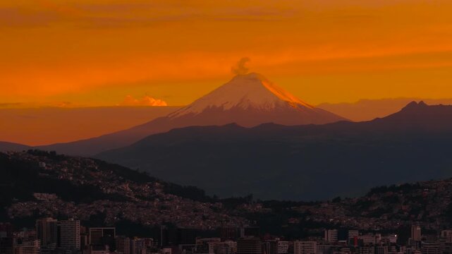 Snow-capped Cotopaxi volcano illuminated by dramatic sunrise light, seen from the mountains above Quito, Ecuador in the Andes.