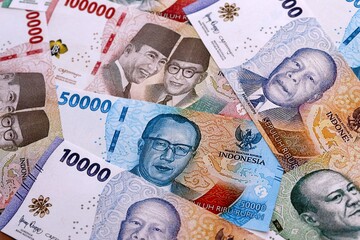 Indonesian rupiah money bills pile on table. Indonesia banknotes of IDR currency close up. © Larysa