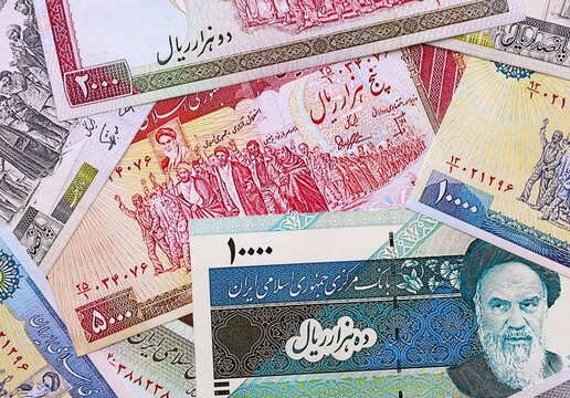 Iranian rial money bills pile on table. Iran banknotes of IRR currency close up.