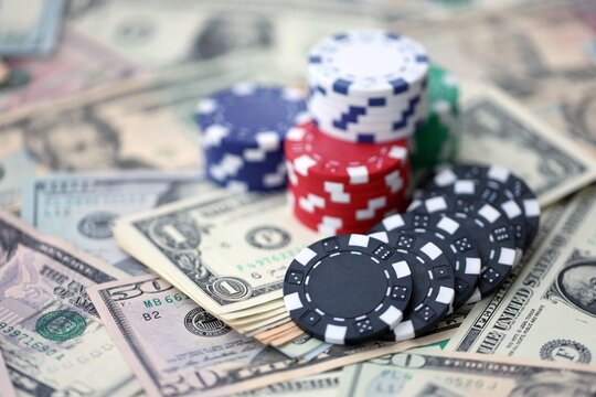 Casino poker chips on US dollar bills close up. Few amount of casino chips stacks for playing poker
