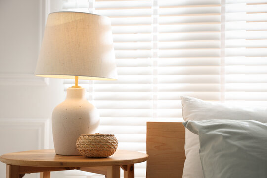 Beautiful lamp on bedside table at home