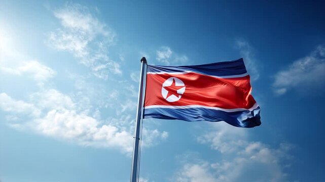north korean flag waving in blue sky. flag of north korea