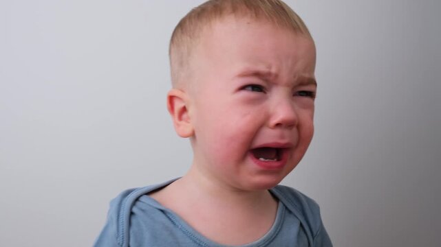 Close-up of a Sad Toddler Boy Crying and Distressed on a White Background