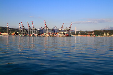 Naklejka premium Industrial Port Scene with Towering Container Cranes