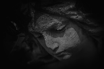 Naklejka premium Abstract dark portrait of eroded statue, concept of grief, loss, and suppressed emotion