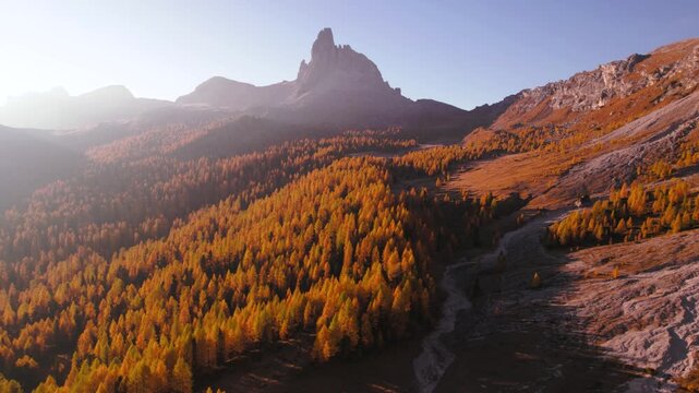 Croda da Lago peak in Dolomites, Italy at sunrise. Golden larch forest valley underneath the mountain