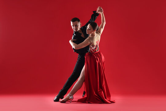 Couple of professional dancers on red background