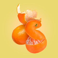 Fresh juicy tangerines falling against yellow background