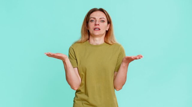 Middle-aged woman performs facepalm and rubs forehead, clearly showing regret, disappointment or realization of a mistake. Girl isolated on blue background displays emotional reaction of frustration.