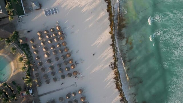 Aerial View of Tropical Beach Resort with Umbrellas and Ocean Waves in Playa del Carmen Mexico