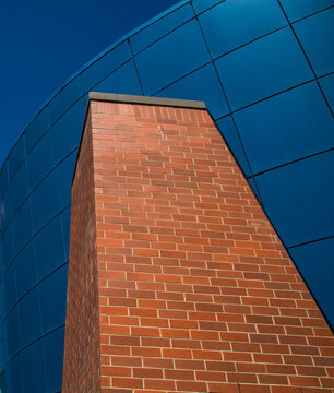 Canada, Alberta, Calgary, An old brick smokestack juxtaposed in front of modern glass office building.
