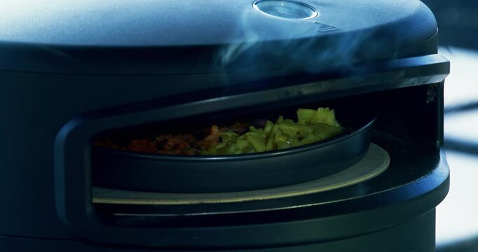 Steam coming from delicious food rotating in pizza oven - closeup