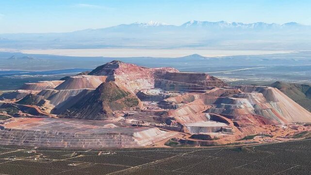 Aerial view of a large gold and silver mine operation digging out amazing portions of a mountain in Mojave, California.