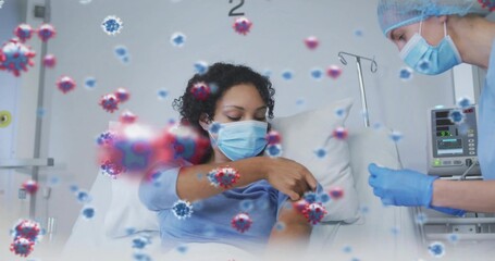 Fototapeta premium Standing nurse prepping shot at bed, patient exposing forearm masked, nurse wearing gloves