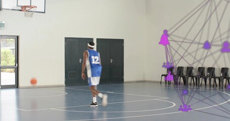 Walking male player in blue jersey 12 moving across gym court, purple overlay, ball rolling left