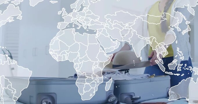 Woman packing suitcase, placing hat, folding clothes, closing, world map overlay suggesting travel