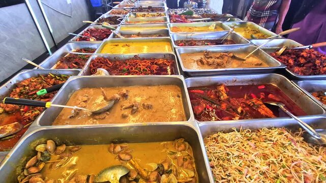 Pan up of local Malay dishes sold at a local eatery in Malaysia. These Malay dishes were normally tasted spicy which was too hot for foreign tourist