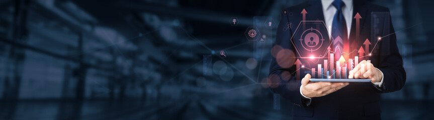 Naklejka na ściany i meble Businessman using a tablet for analyzing business targeting data and information, market segmentation, customer insights, strategic planning, sales optimization, advertising strategy.