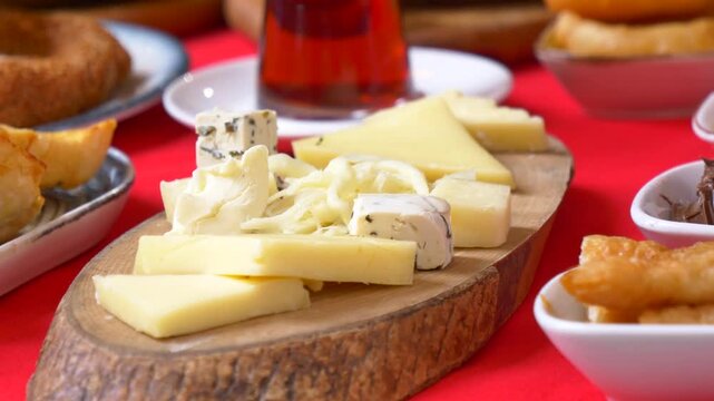 A close up cinematic shot of a delicious traditional turkish breakfast, a red tablecloth is visible in the background
