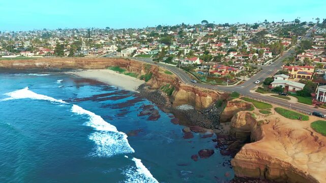 Drone shot of Del Mar city with coastal cliffs, sandy beach and Pacific Ocean waves along shoreline