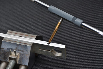 Threading tool in action on a aluminum piece. Tapping tool to create thread. Metal tap and drive...