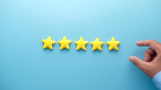 Hand places yellow star on blue background completing five star rating