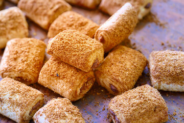 Laminated filled rolls with a crispy texture and sweet topping displayed on a baking surface ready...