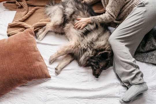 A woman laying on the floor with her dog.