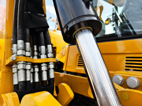 Hydraulic system close-up on construction equipment showcasing machinery details in bright daylight