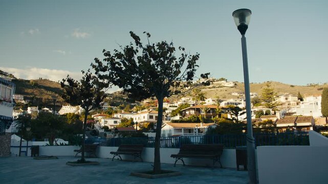 Peaceful plaza with benches and trees overlooking hillside homes in Almu&ntilde;&eacute;car, Andalusia, southern Spain.