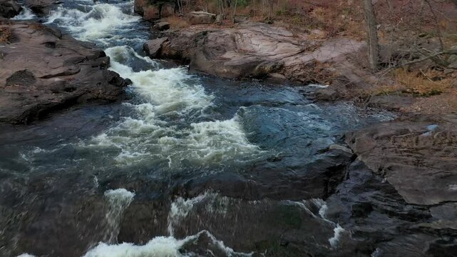 Flying at very low altitude over the rapids, going upstream and following the path of the river.
