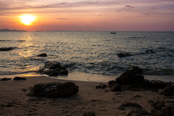 Golden Sunset Over Calm Ocean With Rocky Beach