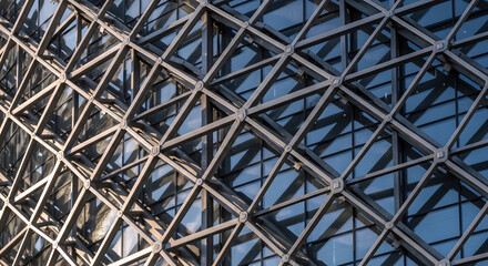 Modern building facade with geometric glass and metal structure, architectural detail, abstract background