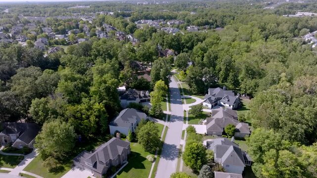Neighborhood homes in Carmel, Indiana with drone video moving forward.