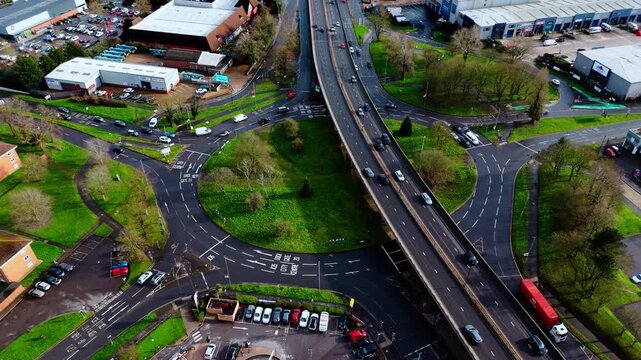 aerial Birds Eye overhead shot over the Millbrook flyover roundabout in Southampton, Hampshire, England. Shot at sunset in winter with bright light shining as the cars pass over the industrial suburb.