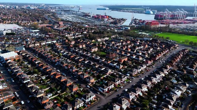 aerial drone shot high angle over the Millbrook suburban housing area estate in Southampton at sunset with trees, homes and nature surrounding. Shot in winter with traffic and cars driving the streets