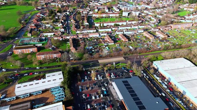 aerial drone shot high angle over the Millbrook suburban housing area estate in Southampton at sunset with trees, homes and nature surrounding. Shot in winter with traffic and cars driving the streets