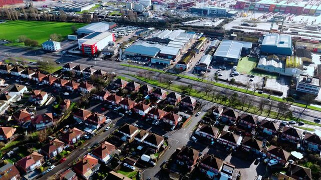 aerial drone shot high angle over the Millbrook suburban housing area estate in Southampton at sunset with trees, homes and nature surrounding. Shot in winter with traffic and cars driving the streets