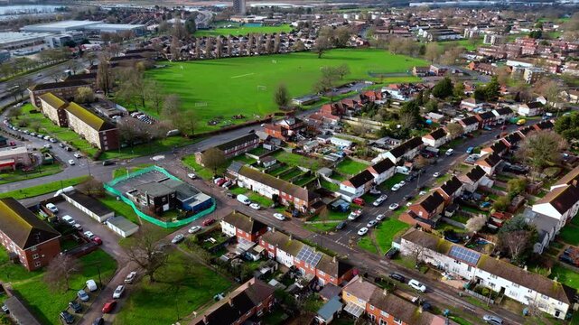 aerial drone shot high angle over the Millbrook suburban housing area estate in Southampton at sunset with trees, homes and nature surrounding. Shot in winter with traffic and cars driving the streets