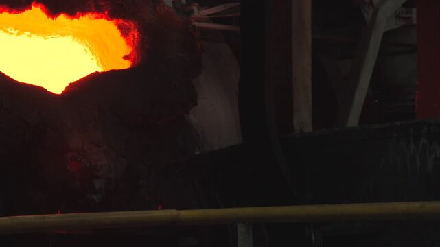 Bright Molten Metal Pouring Highlight. Crucible Spilling Glowing Metal Into Mold Under Bright Light . Stock clip