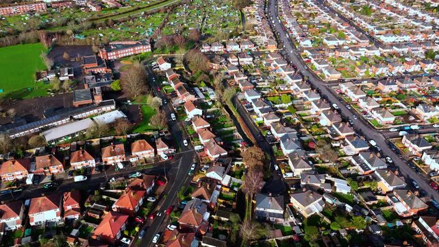 aerial drone shot high angle over the Millbrook suburban housing area estate in Southampton at sunset with trees, homes and nature surrounding. Shot in winter with traffic and cars driving the streets