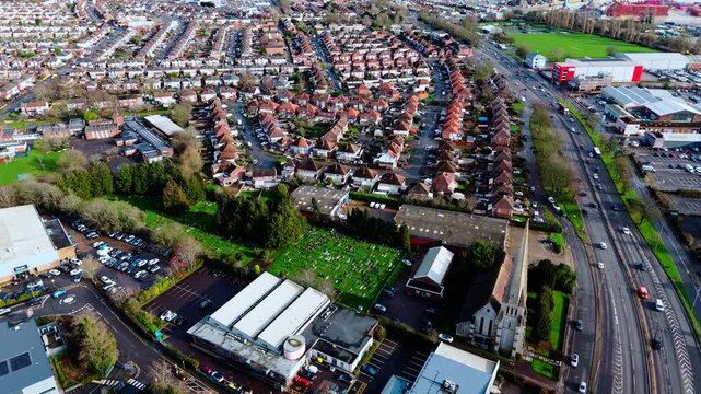 aerial drone shot high angle over the Millbrook suburban housing area estate in Southampton at sunset with trees, homes and nature surrounding. Shot in winter with traffic and cars driving the streets